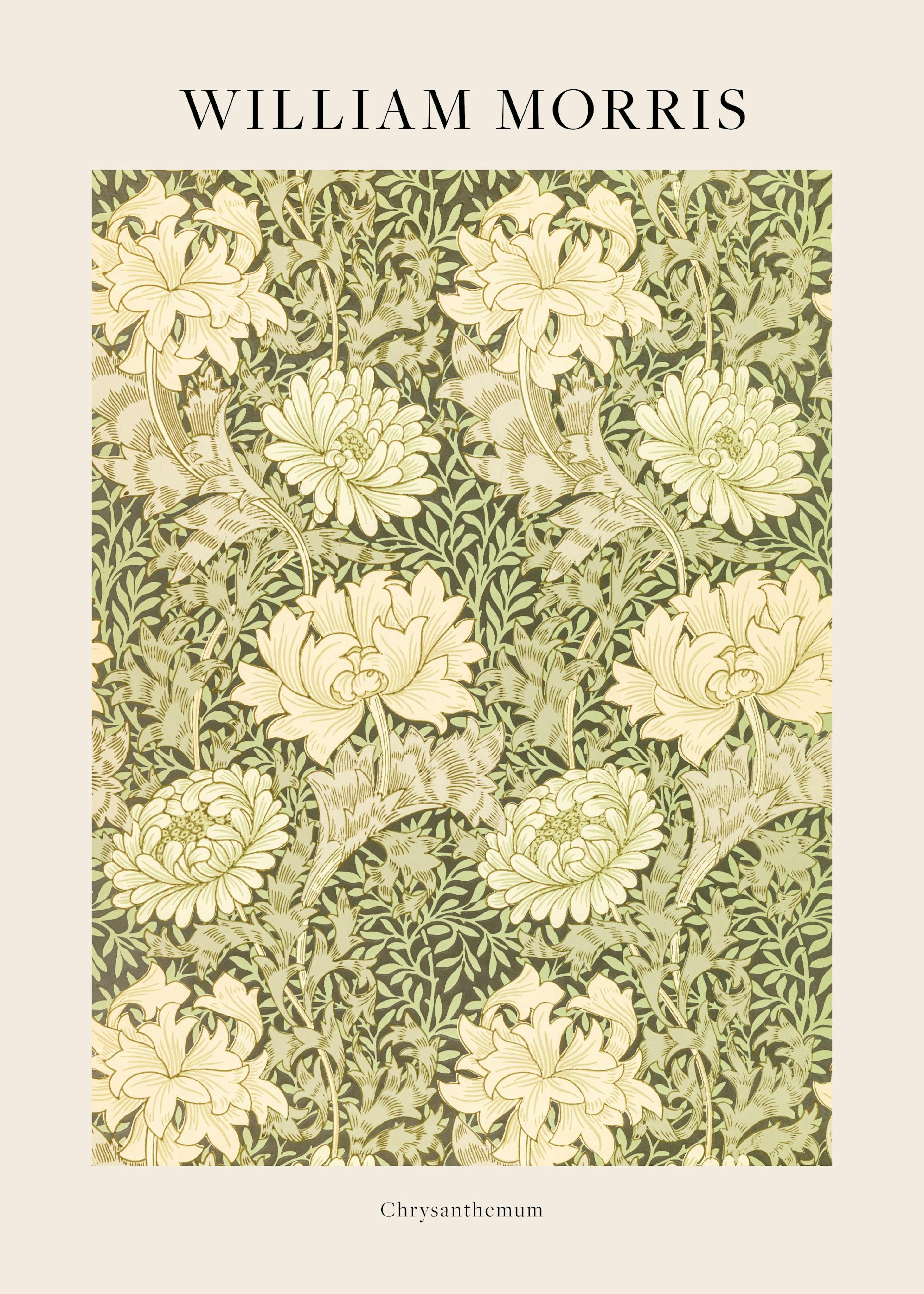 Poster William Morris Chrysanthemum floral vert et crème, accroché au mur au-dessus dune table avec un livre et une tasse.